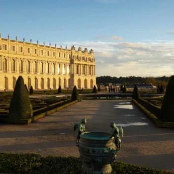 Jardins du Château de Versailles au coucher du soleil avec vue sur la façade ouest et les parterres sculptés