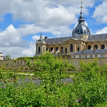 Vue du Potager du Roi à Versailles avec l’ancienne chapelle royale en arrière-plan sous un ciel bleu