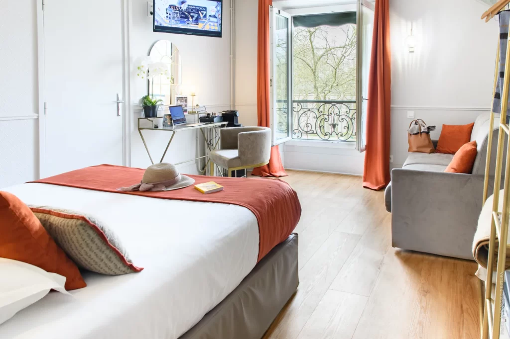 Chambre supérieure quadruple avec coin salon et grande fenêtre à Versailles